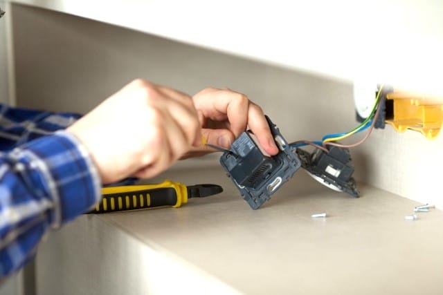 ドライバーを使って修理をしている手